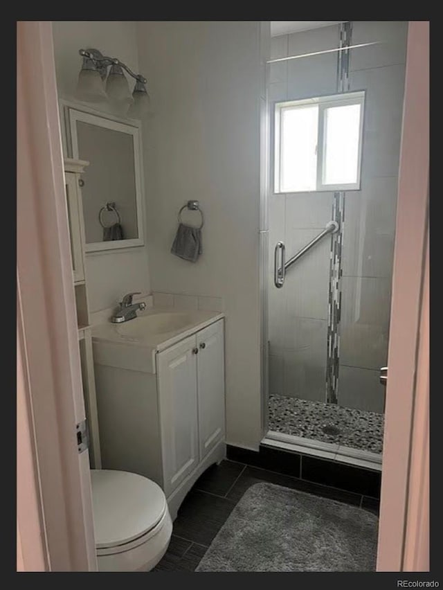 3905 Nelson St, Wheat Ridge, CO 80033 - bathroom featuring a stall shower, vanity, toilet, and tile patterned floors