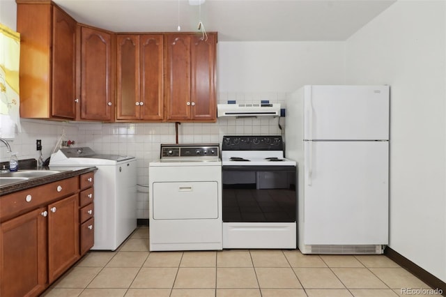 kitchen featuring light tile patterned floors, sink, range with electric cooktop, white refrigerator, and washing machine and clothes dryer