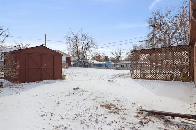 yard covered in snow with a storage shed