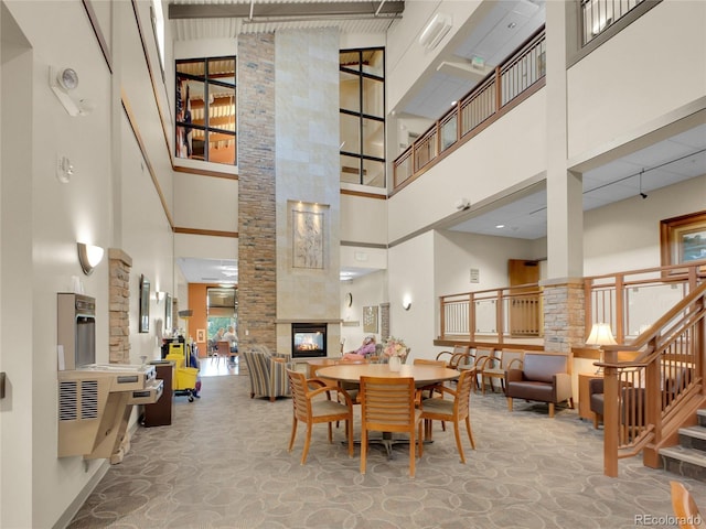 3144 S Wheeling Way Unit 206, Aurora, CO 80014 - dining room featuring a towering ceiling, stairway, and a tiled fireplace