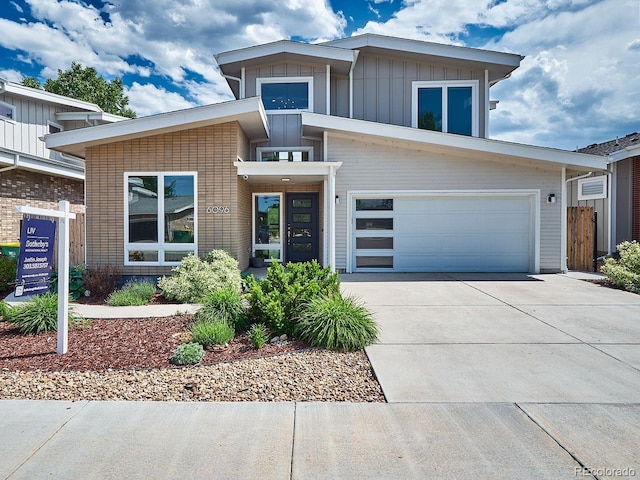 6096 W Keene Ave, Denver, CO 80235 - contemporary home with driveway, board and batten siding, and an attached garage