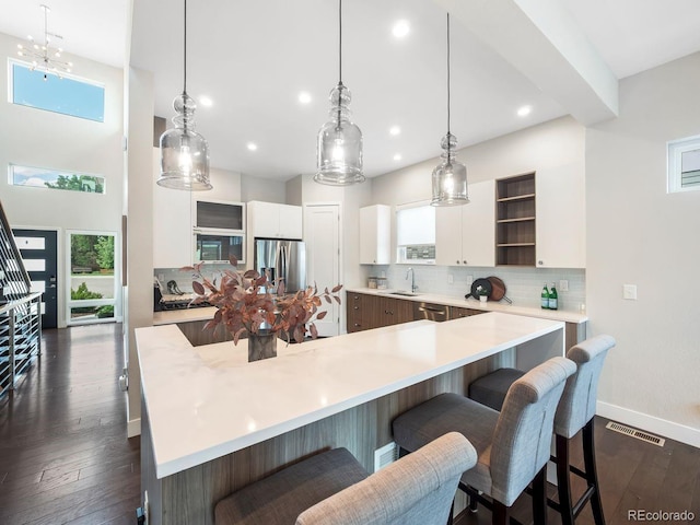 6096 W Keene Ave, Denver, CO 80235 - kitchen with a kitchen breakfast bar, open shelves, decorative backsplash, light countertops, and recessed lighting
