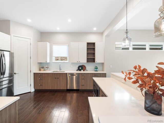 6096 W Keene Ave, Denver, CO 80235 - kitchen with appliances with stainless steel finishes, light countertops, decorative backsplash, hanging light fixtures, and recessed lighting