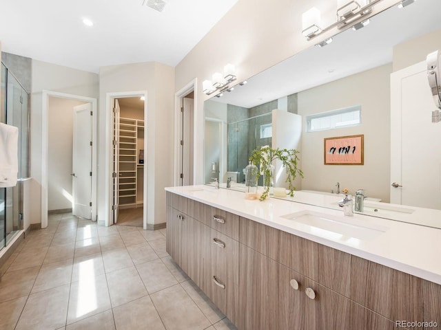 6096 W Keene Ave, Denver, CO 80235 - full bathroom featuring a stall shower, double vanity, a spacious closet, and tile patterned floors