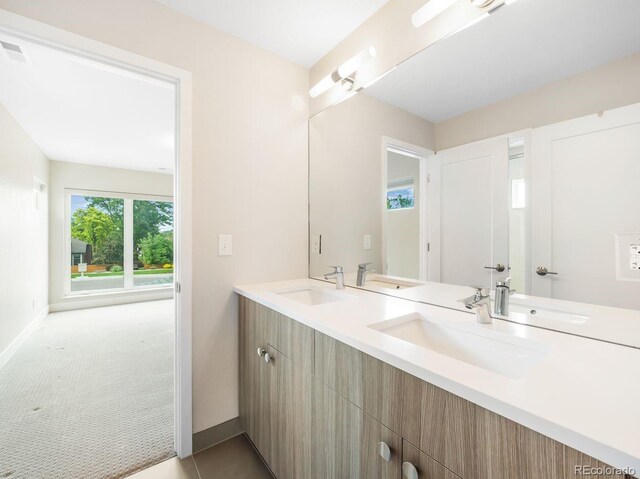 6096 W Keene Ave, Denver, CO 80235 - bathroom featuring baseboards and double vanity