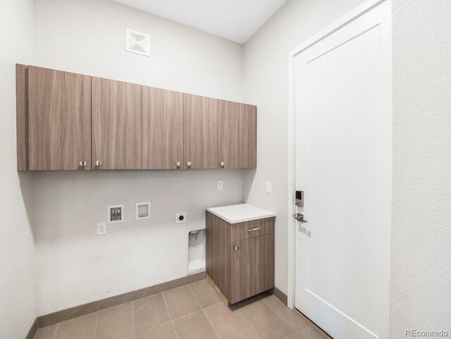 6096 W Keene Ave, Denver, CO 80235 - laundry area with hookup for an electric dryer, cabinet space, hookup for a washing machine, and light tile patterned floors