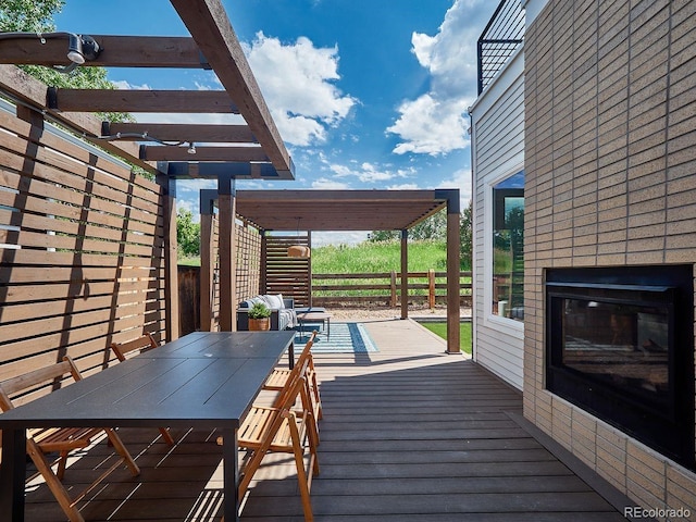 6096 W Keene Ave, Denver, CO 80235 - wooden terrace with outdoor dining space, a brick fireplace, and a pergola