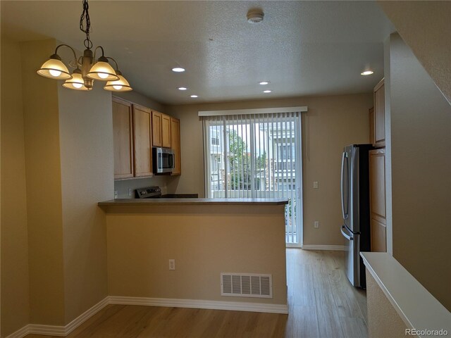 9578 Pearl Cir Unit 105, Parker, CO 80134 - kitchen featuring stainless steel appliances, light wood finished floors, recessed lighting, a chandelier, and baseboards