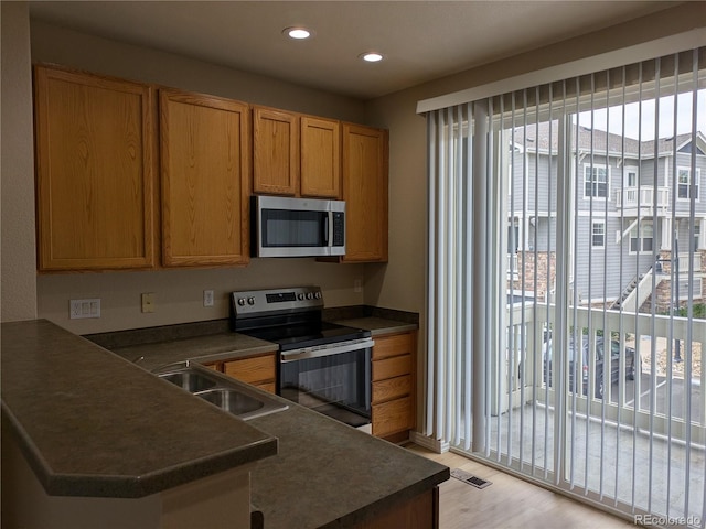 9578 Pearl Cir Unit 105, Parker, CO 80134 - kitchen featuring stainless steel microwave, range with electric cooktop, dark countertops, a peninsula, and a sink