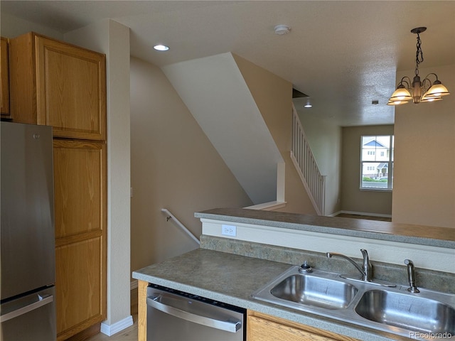 9578 Pearl Cir Unit 105, Parker, CO 80134 - kitchen with stainless steel appliances, a sink, a chandelier, hanging light fixtures, and recessed lighting