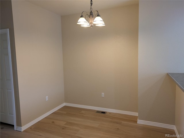 9578 Pearl Cir Unit 105, Parker, CO 80134 - spare room featuring light wood-style flooring, a chandelier, and baseboards