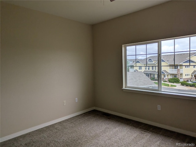 9578 Pearl Cir Unit 105, Parker, CO 80134 - carpeted spare room featuring baseboards, a ceiling fan, and a residential view