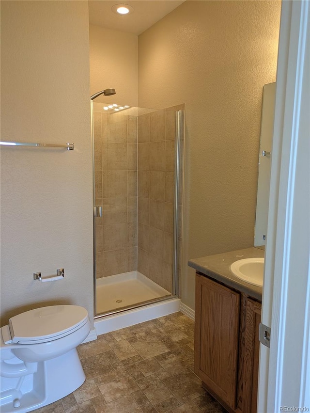 9578 Pearl Cir Unit 105, Parker, CO 80134 - bathroom with a shower stall, toilet, vanity, and stone finish flooring