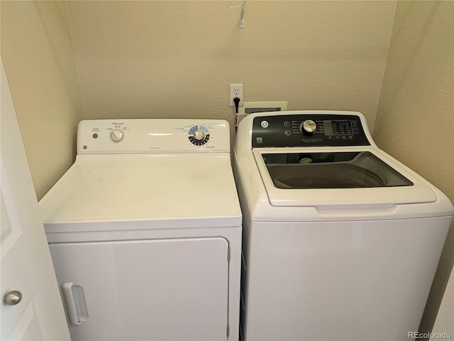 9578 Pearl Cir Unit 105, Parker, CO 80134 - washroom featuring washing machine and clothes dryer and a textured wall