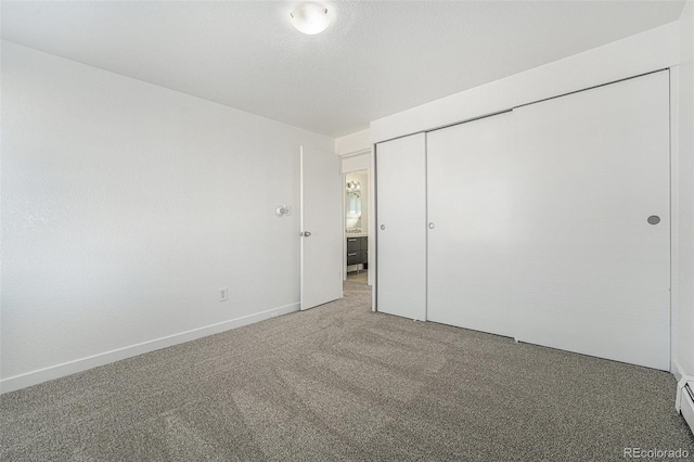 unfurnished bedroom featuring a baseboard radiator, carpet flooring, and a closet