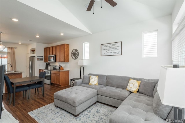 living area with healthy amount of natural light, dark wood finished floors, a ceiling fan, recessed lighting, and vaulted ceiling