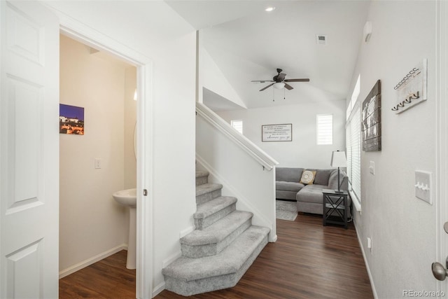 stairs featuring ceiling fan, wood finished floors, lofted ceiling, and baseboards