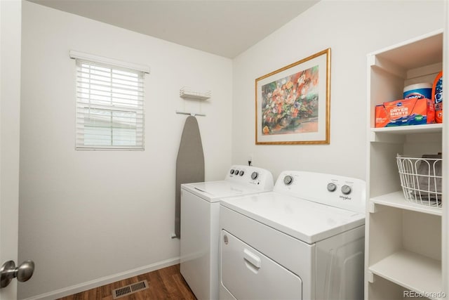 clothes washing area with separate washer and dryer, dark wood finished floors, and baseboards