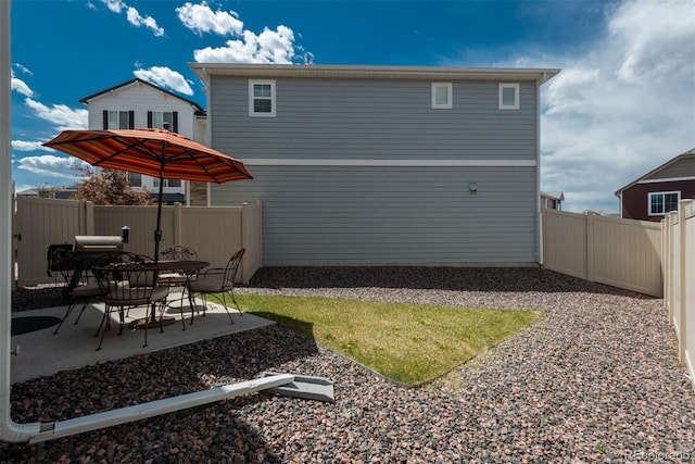 rear view of property with a patio area and a fenced backyard