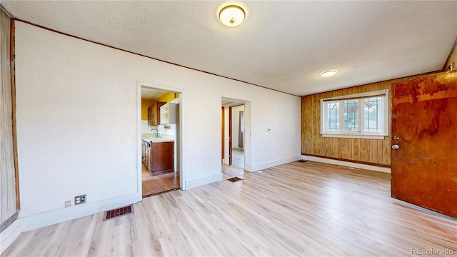 598 S Navajo St, Denver, CO 80223 - empty room featuring light wood-type flooring and a textured ceiling