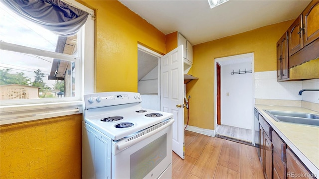 598 S Navajo St, Denver, CO 80223 - kitchen with white electric stove, light countertops, light wood-type flooring, brown cabinetry, and stainless steel dishwasher