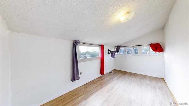 598 S Navajo St, Denver, CO 80223 - spare room with a textured ceiling, wood finished floors, and vaulted ceiling