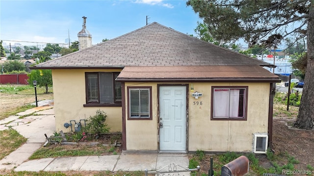 598 S Navajo St, Denver, CO 80223 - view of front of home with a shingled roof, stucco siding, and a chimney