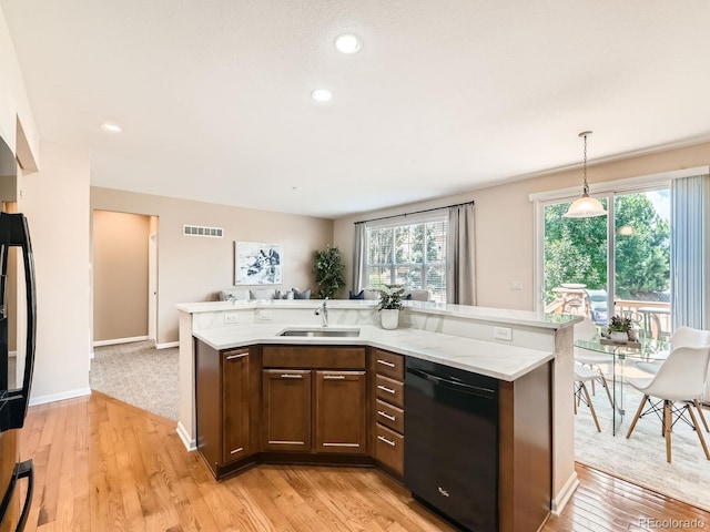 4561 Hope Cir, Broomfield, CO 80023 - kitchen with black dishwasher, healthy amount of natural light, open floor plan, light wood finished floors, and recessed lighting