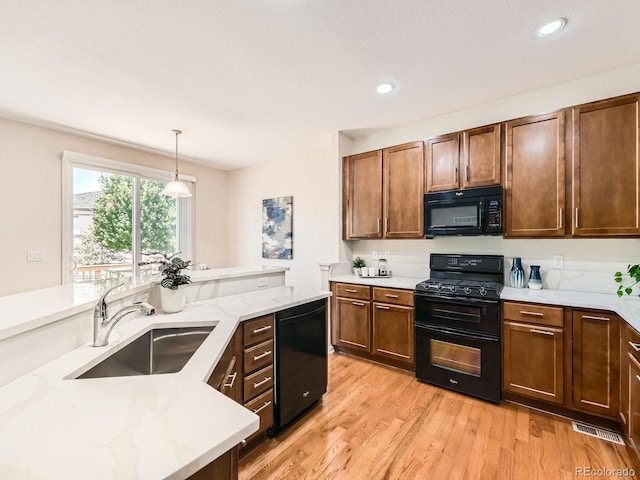 4561 Hope Cir, Broomfield, CO 80023 - kitchen featuring black appliances, pendant lighting, light stone counters, light wood finished floors, and recessed lighting