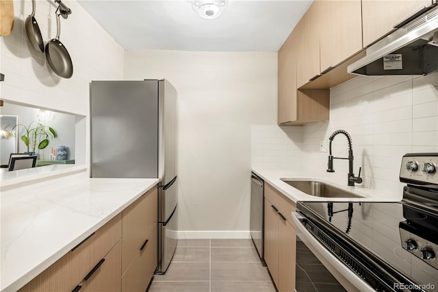 kitchen with tasteful backsplash, stainless steel appliances, sink, and light brown cabinets