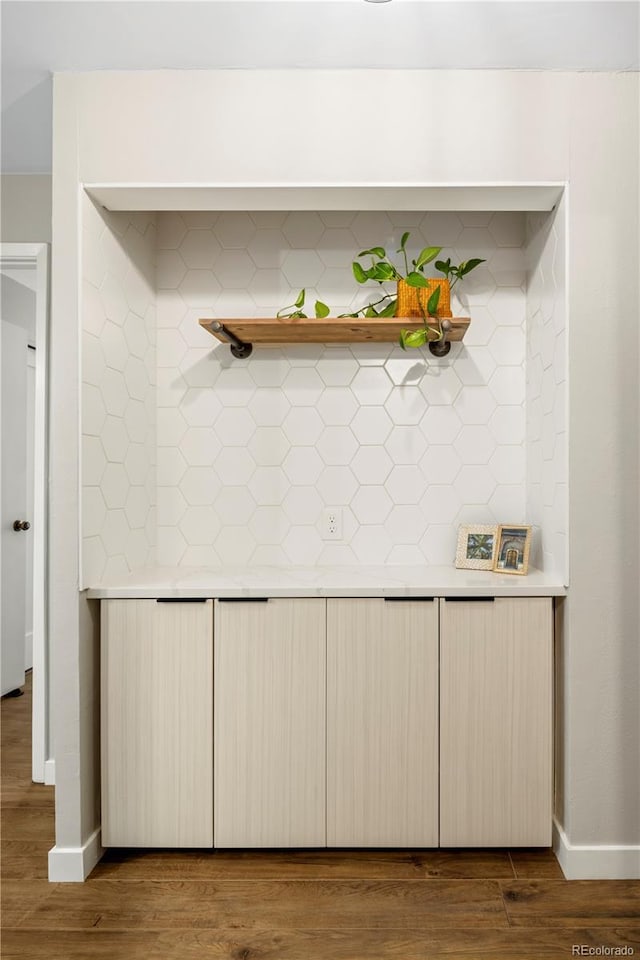 interior details featuring hardwood / wood-style flooring and backsplash