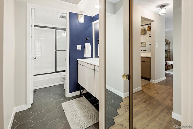 full bathroom featuring vanity, tile patterned floors, shower / bath combination with glass door, and toilet