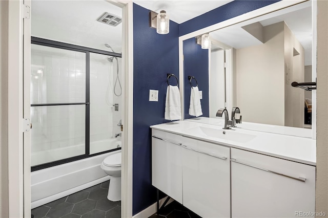 full bathroom with shower / bath combination with glass door, vanity, toilet, and tile patterned flooring