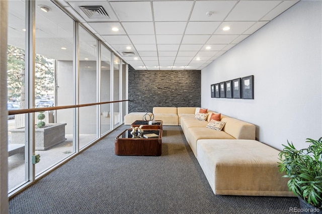 living room with a paneled ceiling and carpet floors