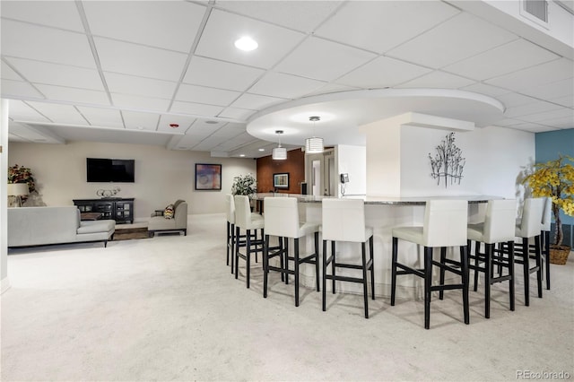 interior space featuring a paneled ceiling and light colored carpet