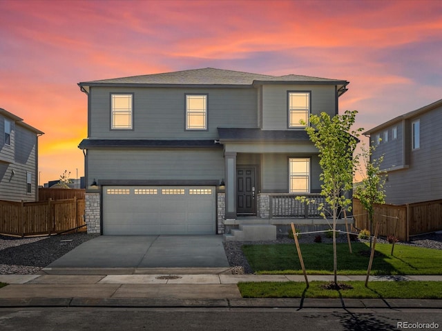 8850 Sedalia St, Commerce City, CO 80022 - view of front of home featuring covered porch, a garage, driveway, and stone siding