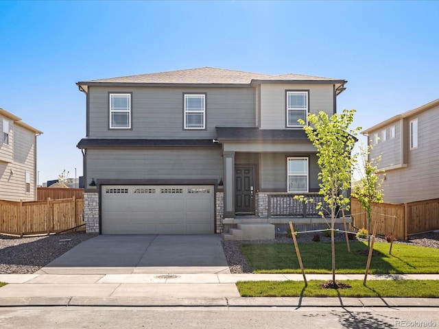 8850 Sedalia St, Commerce City, CO 80022 - view of front of house featuring a porch, an attached garage, driveway, and stone siding