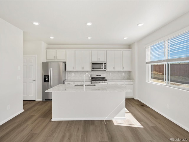 8850 Sedalia St, Commerce City, CO 80022 - kitchen featuring stainless steel appliances, a sink, white cabinets, an island with sink, and recessed lighting