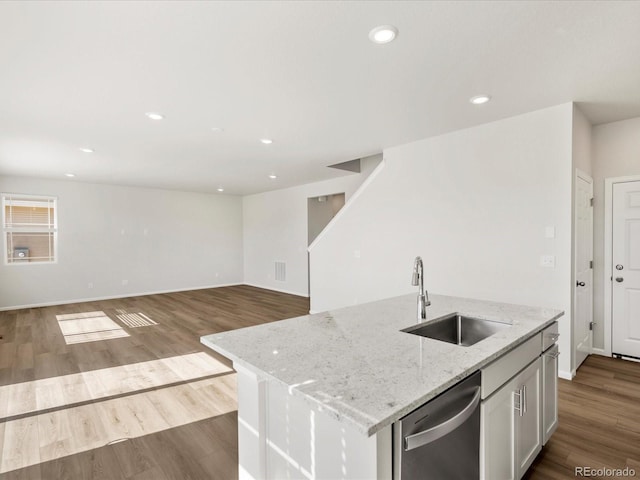 8850 Sedalia St, Commerce City, CO 80022 - kitchen with a sink, stainless steel dishwasher, dark wood-type flooring, light stone counters, and a center island with sink