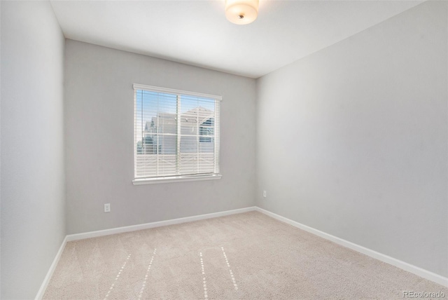 spare room featuring carpet and baseboards