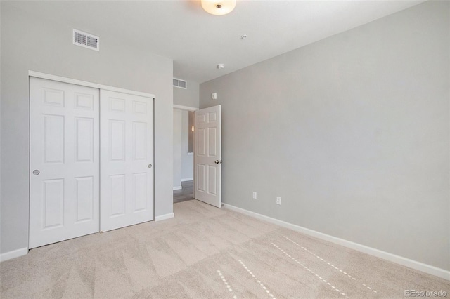 unfurnished bedroom featuring a closet and light carpet