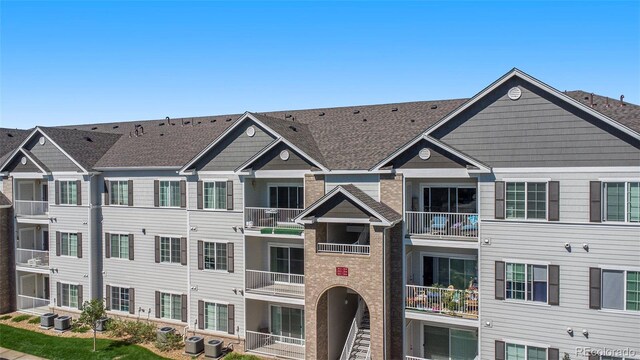 view of front of house with a balcony and central AC unit