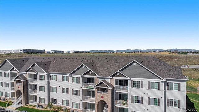 view of front of house featuring a mountain view and a balcony