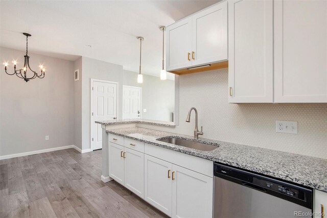 kitchen with white cabinets, stainless steel dishwasher, sink, and light stone counters