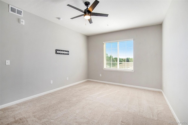 unfurnished room with light carpet, visible vents, a ceiling fan, and baseboards