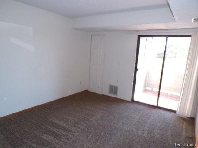 empty room featuring dark carpet