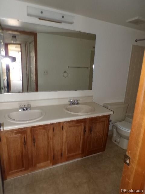 bathroom with vanity, toilet, and tile patterned flooring