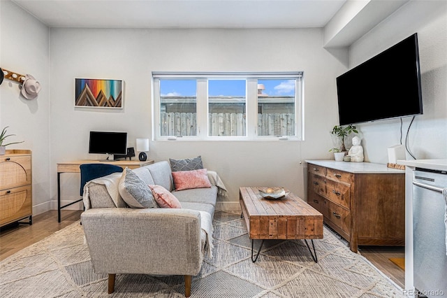 living area with light wood-type flooring and baseboards