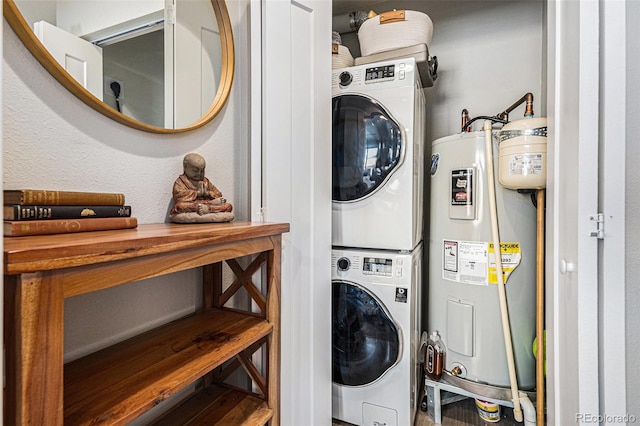 clothes washing area featuring stacked washer and clothes dryer and water heater