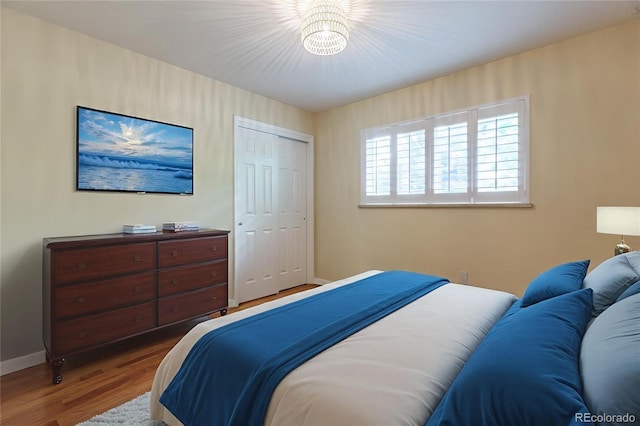 3098 S Vine St, Denver, CO 80210 - bedroom featuring wood finished floors, baseboards, a closet, and a chandelier